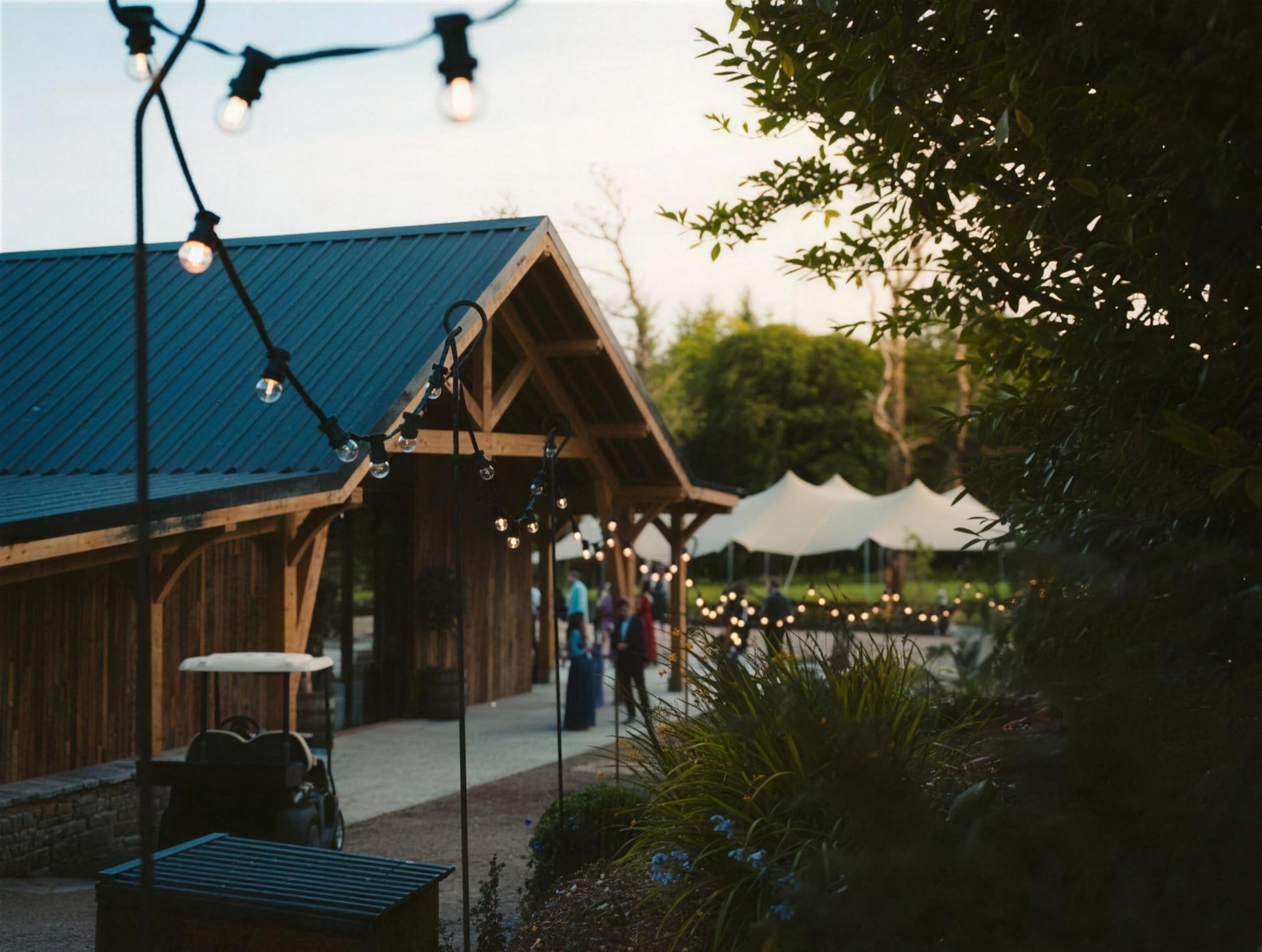 Festoon-lit gathering at the Hideaway Barn at dusk