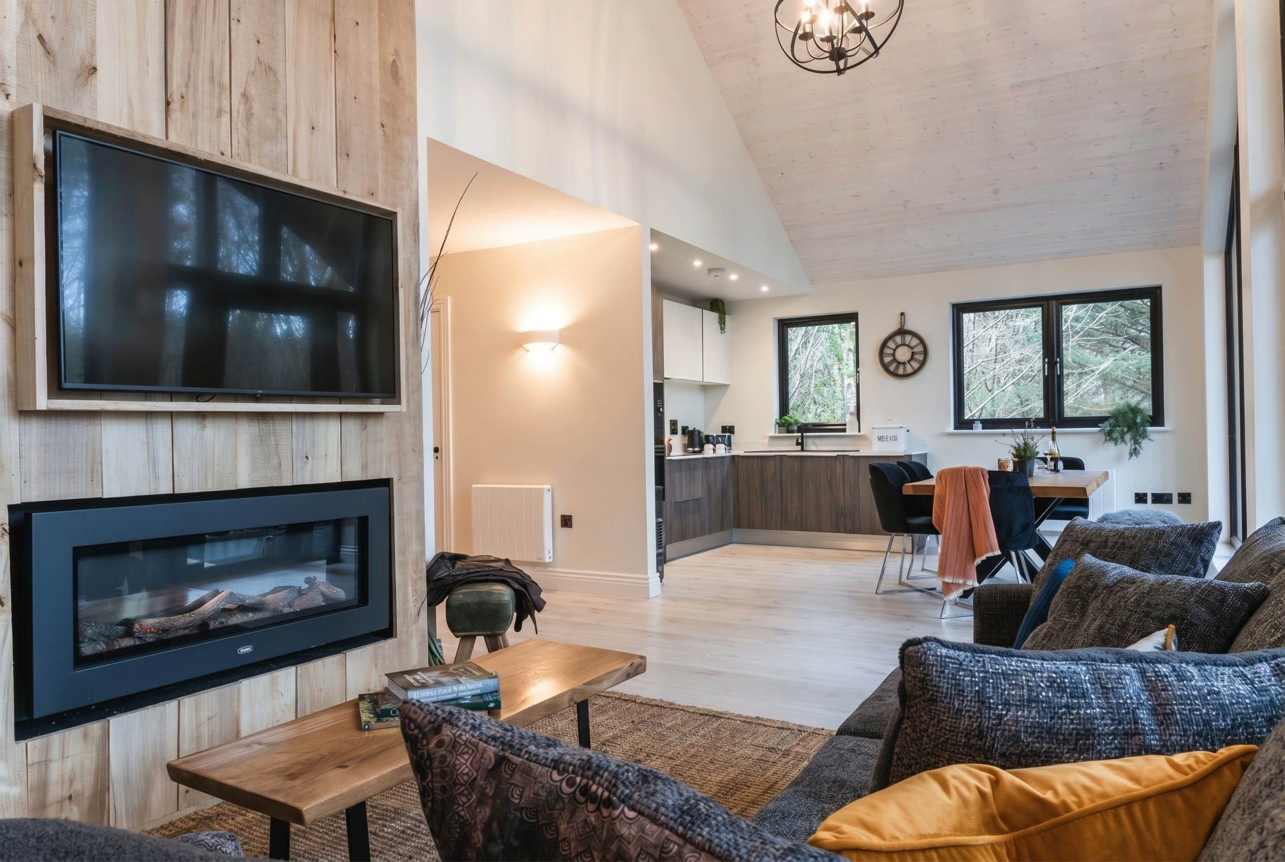 Living room with the fire flickering under a high vaulted ceiling