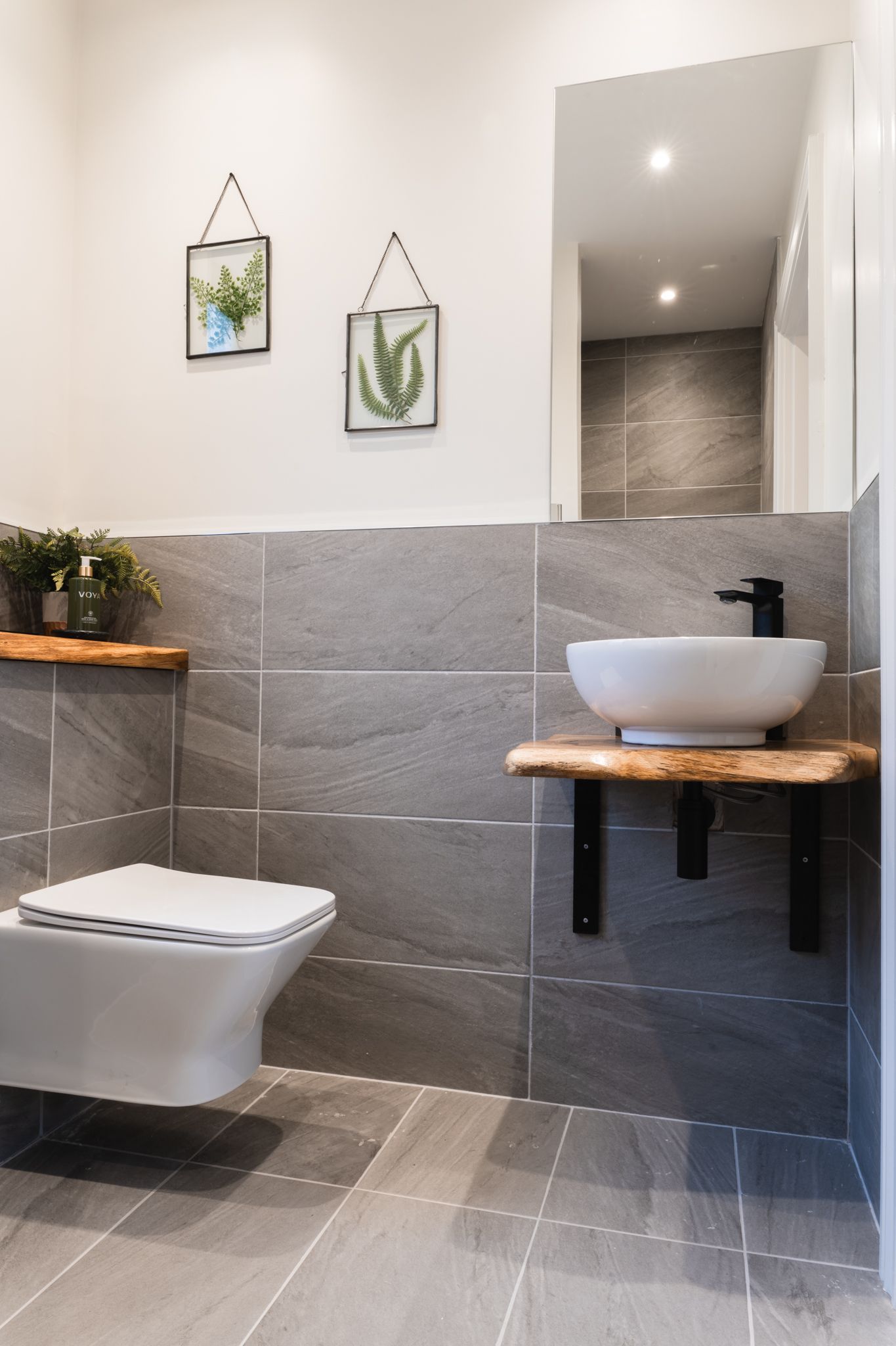 Bathroom in natural stone with a vessel sink and walk-in shower