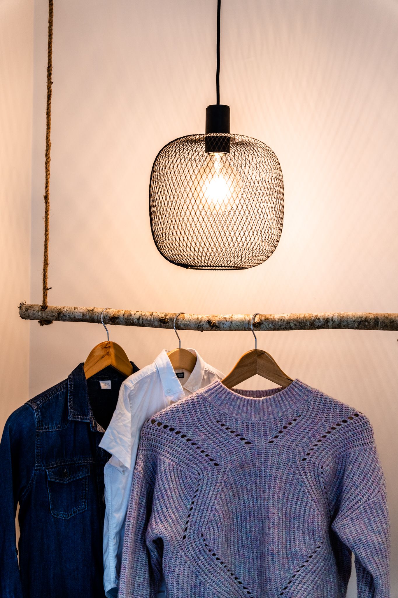 Woven rattan pendant light above a timber rail