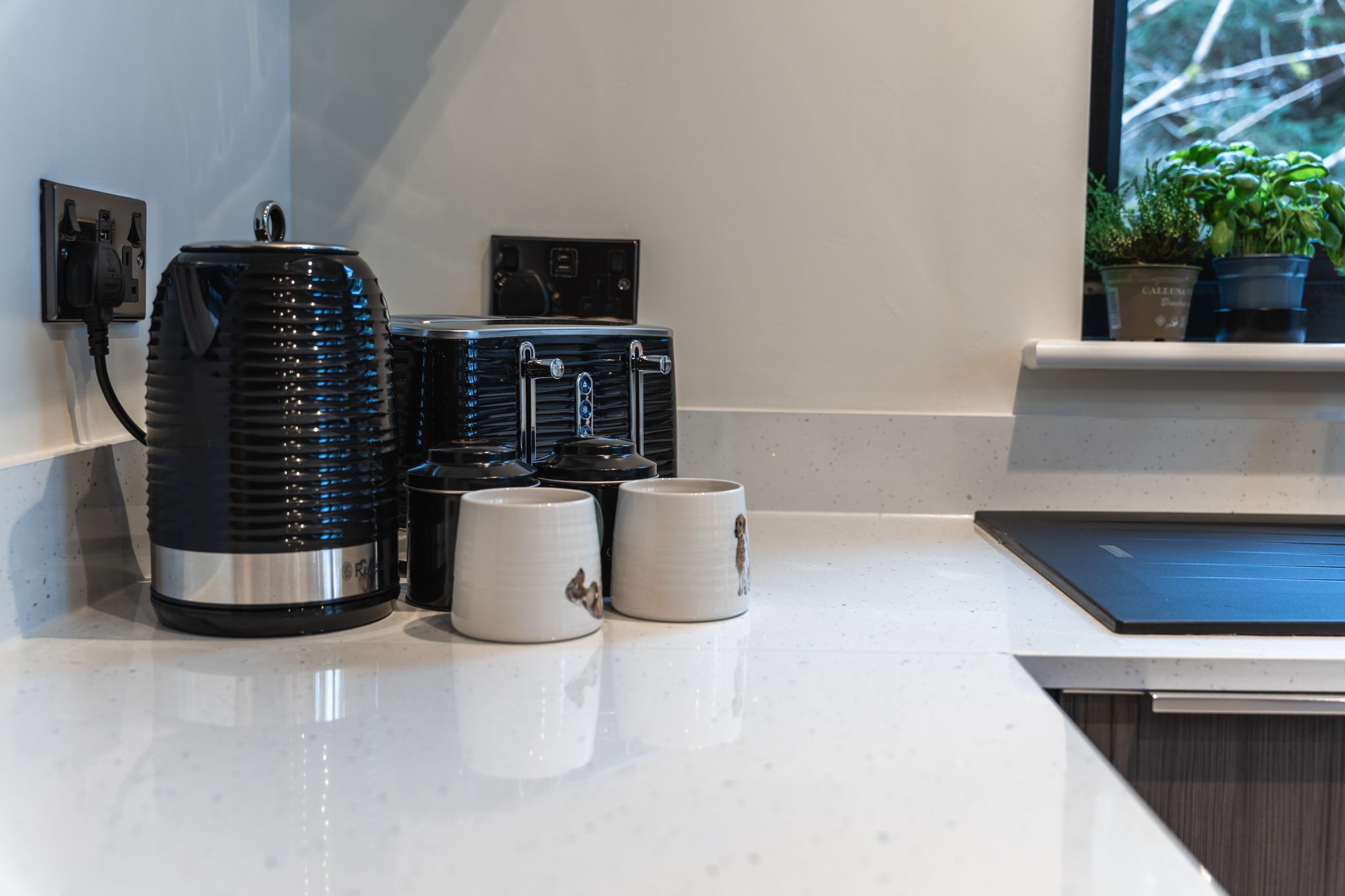 Kitchen detail with a kettle and stoneware mugs