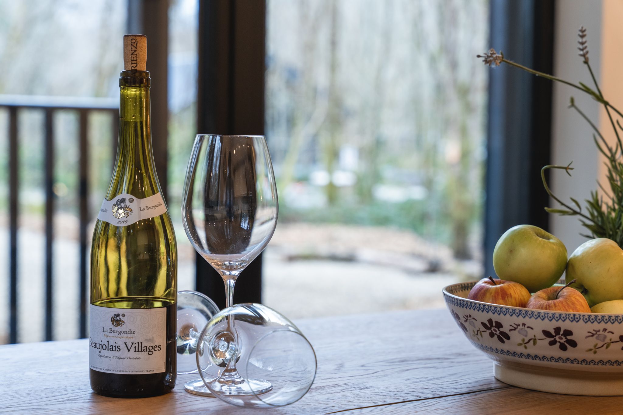 A welcome of wine glasses and fresh fruit by the window