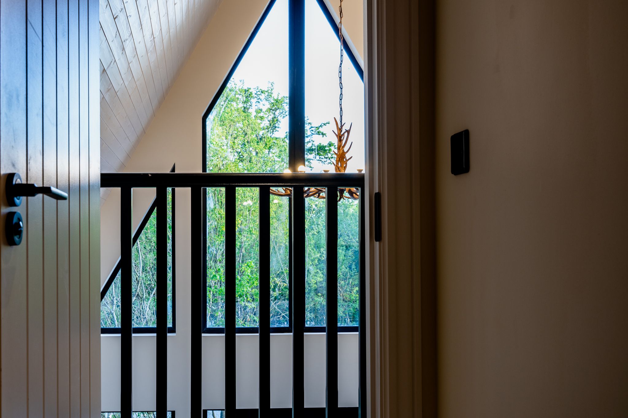 The loft master bedroom under the apex, looking down over the living space